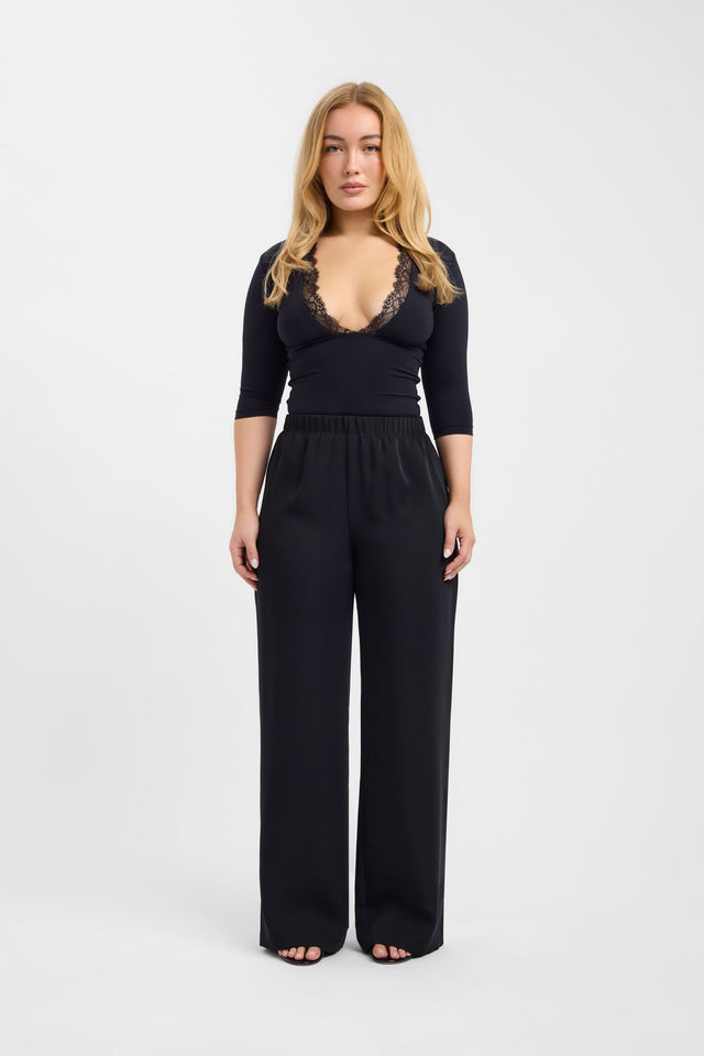 Presenting the Riley Lace Top womens-blouse in black with fitted plunge neckline and three-fourth sleeves on-body